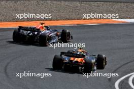 Max Verstappen (NLD) Red Bull Racing RB20 and Lando Norris (GBR) McLaren MCL38 battle for position. 25.08.2024. Formula 1 World Championship, Rd 15, Dutch Grand Prix, Zandvoort, Netherlands, Race Day.