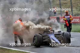 Marshals put out the fire in the Williams Racing FW46 of Logan Sargeant (USA) Williams Racing after he crashed in the third practice session.