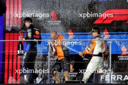 Race winner Lando Norris (GBR) McLaren (Right) celebrates on the podium with Paul Barnes (GBR) McLaren Director of Support and Logistics and Max Verstappen (NLD) Red Bull Racing. 22.09.2024. Formula 1 World Championship, Rd 18, Singapore Grand Prix, Marina Bay Street Circuit, Singapore, Race Day.