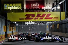 Carlos Sainz Jr (ESP) Ferrari SF-24 and Franco Colapinto (ARG) Williams Racing FW46 at the start of the race. 22.09.2024. Formula 1 World Championship, Rd 18, Singapore Grand Prix, Marina Bay Street Circuit, Singapore, Race Day.