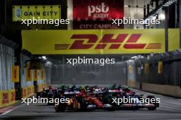 Carlos Sainz Jr (ESP) Ferrari SF-24 and Yuki Tsunoda (JPN) RB VCARB 01 at the start of the race. 22.09.2024. Formula 1 World Championship, Rd 18, Singapore Grand Prix, Marina Bay Street Circuit, Singapore, Race Day.