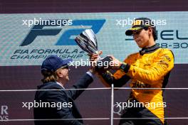 Race winner Gabriel Bortoleto (BRA) Invicta Racing celebrates on the podium with Emerson Fittipaldi (BRA). 30.06.2024. FIA Formula 2 Championship, Rd 7, Feature Race, Spielberg, Austria, Sunday.